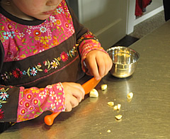 Kleine Köchin bein Knoblauch schneiden